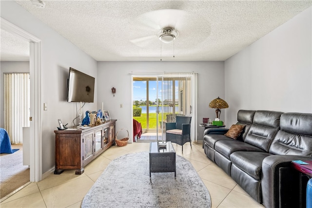 tiled living room featuring ceiling fan and a textured ceiling