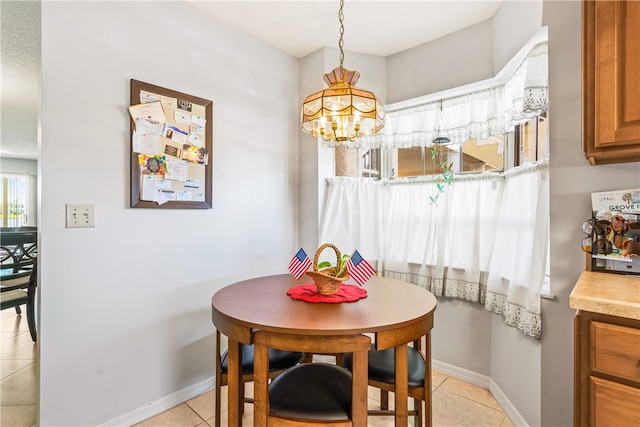 tiled dining space with a chandelier