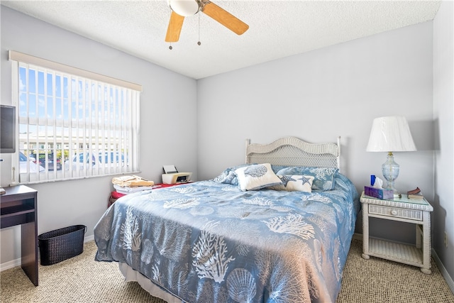 carpeted bedroom with ceiling fan and a textured ceiling