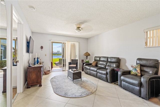 tiled living room featuring ceiling fan and a textured ceiling