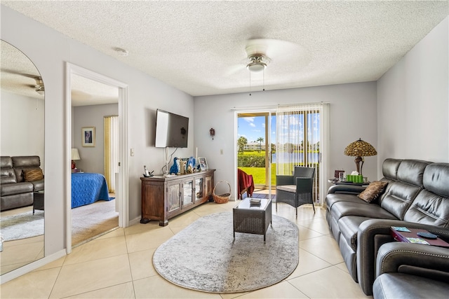 tiled living room featuring a textured ceiling and ceiling fan