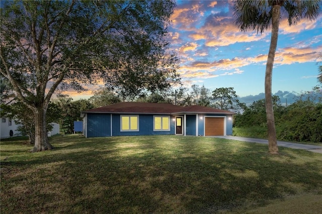 single story home featuring a yard and a garage