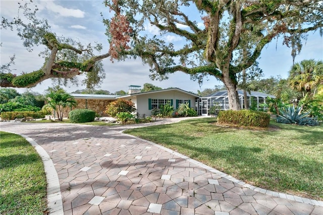 single story home with glass enclosure and a front lawn