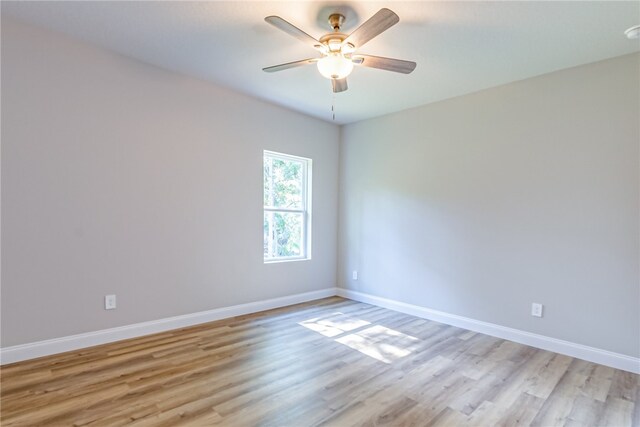 empty room with ceiling fan and light hardwood / wood-style flooring