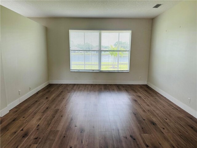 6075 46th Ln, Vero Beach, FL 32967 - spare room with healthy amount of natural light, dark wood-style flooring, and baseboards