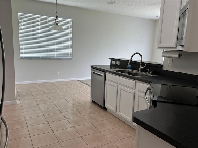 6075 46th Ln, Vero Beach, FL 32967 - kitchen with stainless steel appliances, a sink, dark countertops, white cabinetry, and a textured ceiling