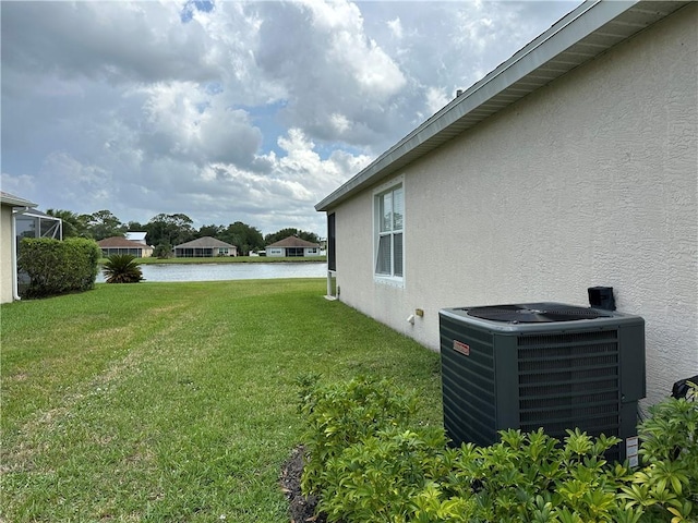 6075 46th Ln, Vero Beach, FL 32967 - view of grassy yard with central AC unit and a water view