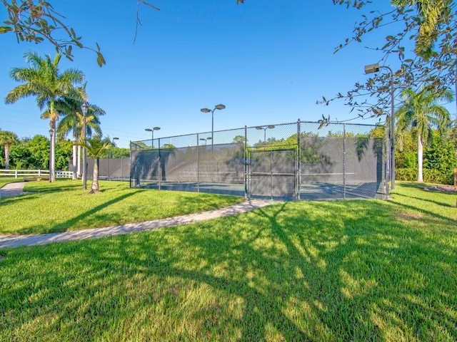 view of tennis court featuring a lawn