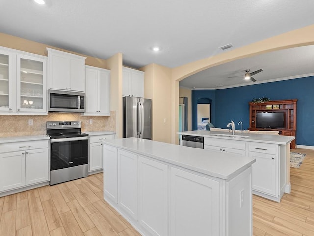 kitchen with sink, white cabinetry, a center island, stainless steel appliances, and backsplash