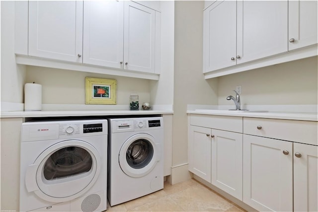 clothes washing area featuring cabinets, washer and clothes dryer, sink, and light tile patterned floors