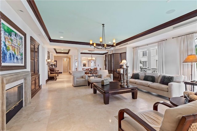 living room with crown molding, an inviting chandelier, decorative columns, a high end fireplace, and a raised ceiling