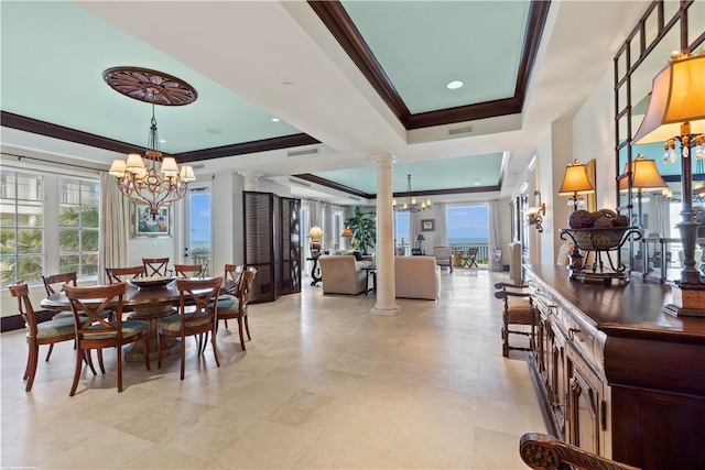 dining space with an inviting chandelier, a tray ceiling, decorative columns, and crown molding