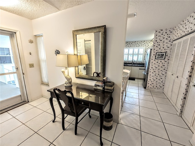 tiled dining area with sink and a textured ceiling