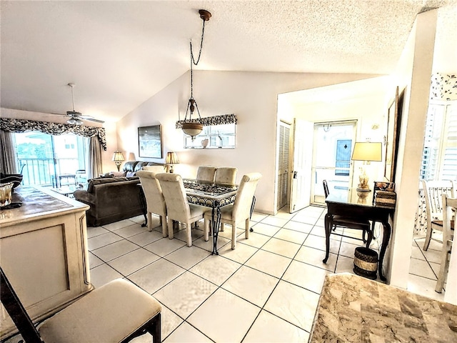 dining space featuring ceiling fan, a textured ceiling, light tile patterned floors, and lofted ceiling