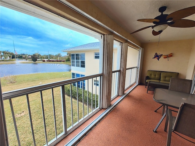 sunroom featuring plenty of natural light, a water view, and ceiling fan