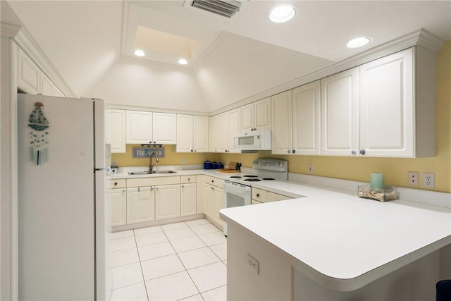 kitchen with white appliances, kitchen peninsula, lofted ceiling, a breakfast bar area, and sink