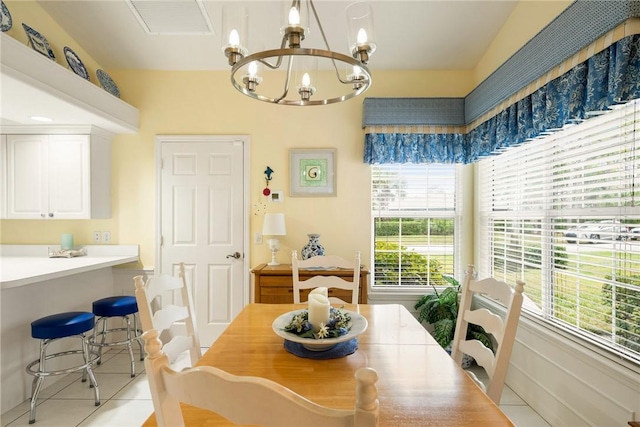 tiled dining space featuring an inviting chandelier