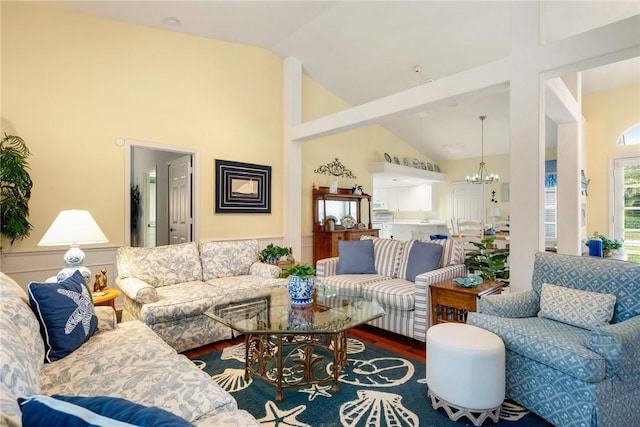 living room with wood-type flooring, high vaulted ceiling, and an inviting chandelier