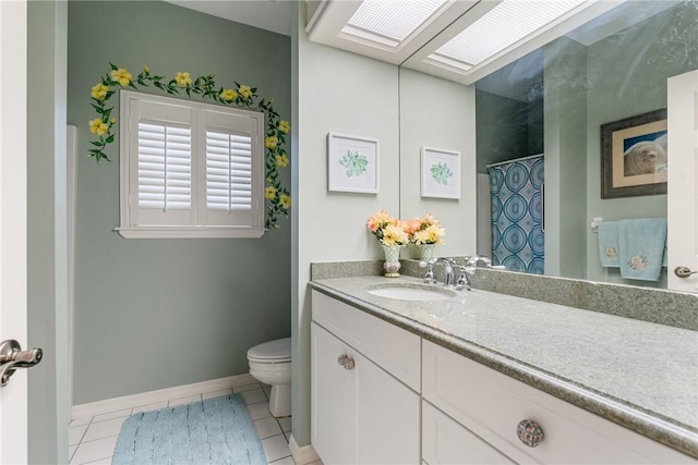 bathroom with vanity, tile patterned flooring, toilet, and a skylight