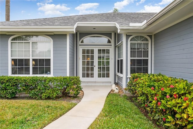 view of exterior entry with french doors and a yard