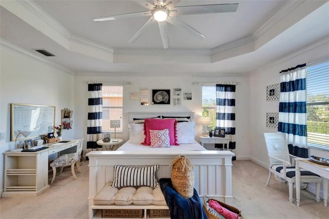 bedroom featuring multiple windows, a raised ceiling, visible vents, and ornamental molding