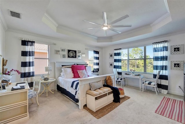 bedroom with visible vents, a raised ceiling, and multiple windows