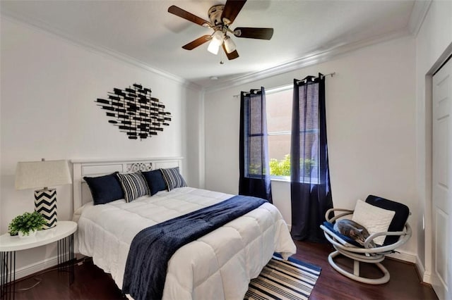 bedroom featuring crown molding, wood finished floors, baseboards, and ceiling fan