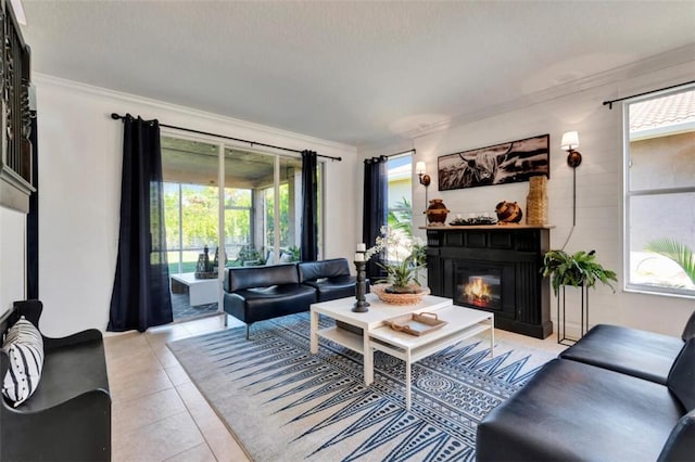 living area with light tile patterned floors, a healthy amount of sunlight, a glass covered fireplace, and crown molding