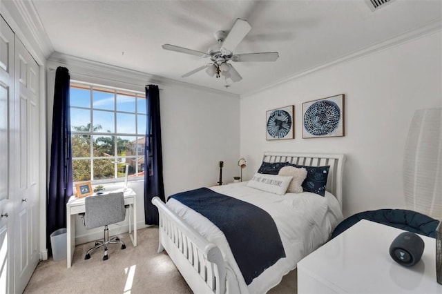 carpeted bedroom with ceiling fan, a closet, baseboards, and ornamental molding