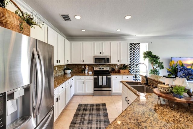 kitchen featuring visible vents, light tile patterned floors, decorative backsplash, appliances with stainless steel finishes, and a sink