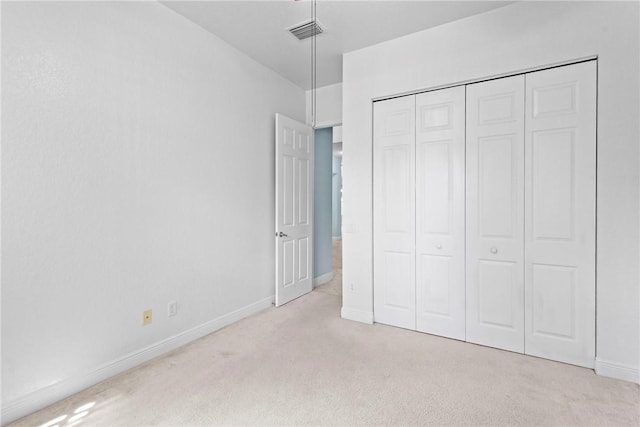 1877 Grey Falcon Cir SW, Vero Beach, FL 32962 - unfurnished bedroom featuring light carpet, baseboards, and a closet