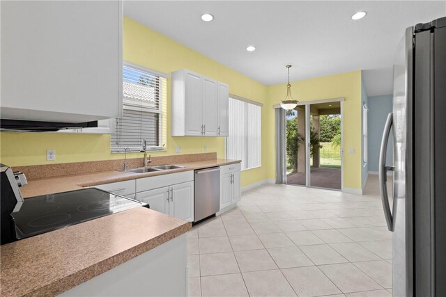 1877 Grey Falcon Cir SW, Vero Beach, FL 32962 - kitchen featuring stainless steel appliances, a sink, white cabinets, decorative light fixtures, and baseboards