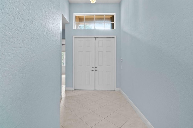 1877 Grey Falcon Cir SW, Vero Beach, FL 32962 - entryway featuring a textured wall, light tile patterned floors, plenty of natural light, and baseboards