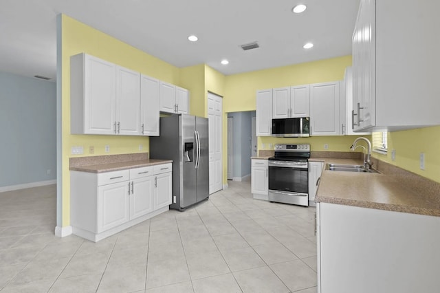1877 Grey Falcon Cir SW, Vero Beach, FL 32962 - kitchen featuring appliances with stainless steel finishes, a sink, white cabinets, recessed lighting, and light tile patterned flooring