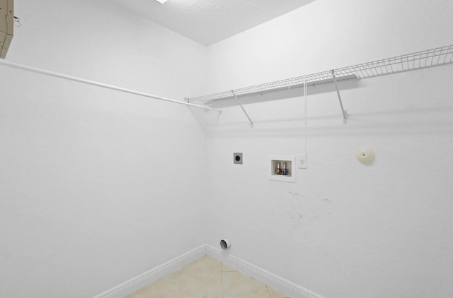 1877 Grey Falcon Cir SW, Vero Beach, FL 32962 - laundry room with electric dryer hookup, baseboards, hookup for a washing machine, and light tile patterned floors