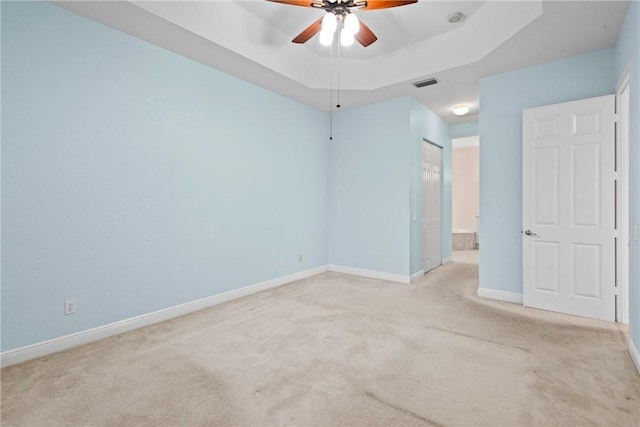 1877 Grey Falcon Cir SW, Vero Beach, FL 32962 - unfurnished bedroom with carpet floors, baseboards, connected bathroom, and a tray ceiling