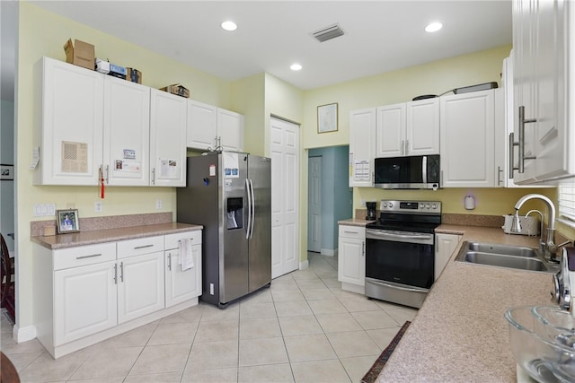 1877 Grey Falcon Cir SW, Vero Beach, FL 32962 - kitchen featuring appliances with stainless steel finishes, a sink, white cabinets, light countertops, and light tile patterned flooring