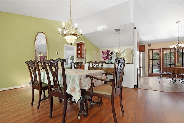 dining room featuring dark hardwood / wood-style flooring, lofted ceiling, and a chandelier