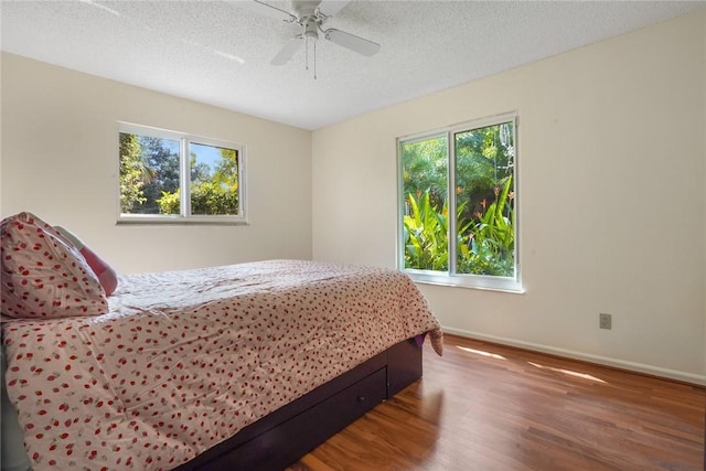 bedroom featuring hardwood / wood-style floors, a textured ceiling, and ceiling fan