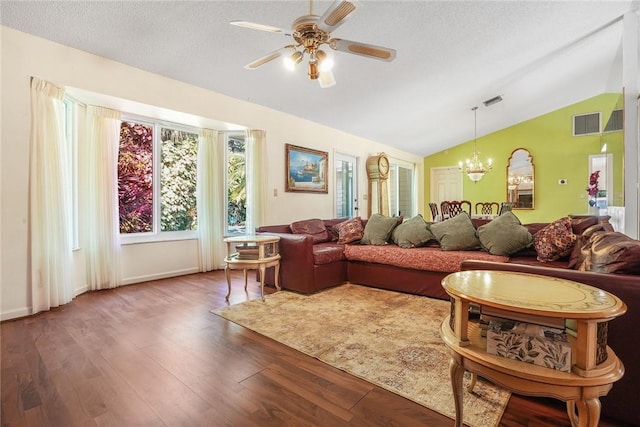 living room with vaulted ceiling, ceiling fan with notable chandelier, hardwood / wood-style floors, and a textured ceiling