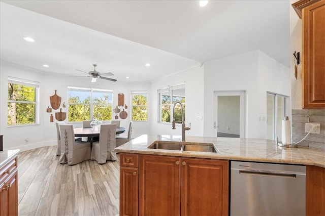 kitchen featuring dishwasher, sink, decorative backsplash, light stone countertops, and light hardwood / wood-style flooring