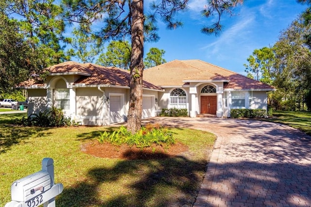 mediterranean / spanish house with a garage and a front yard