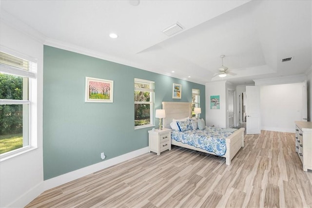 bedroom featuring ornamental molding, a raised ceiling, ceiling fan, and light wood-type flooring