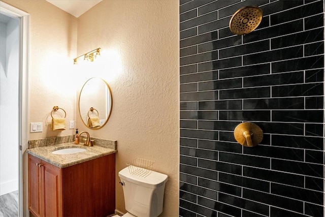 bathroom with vanity, toilet, and a shower