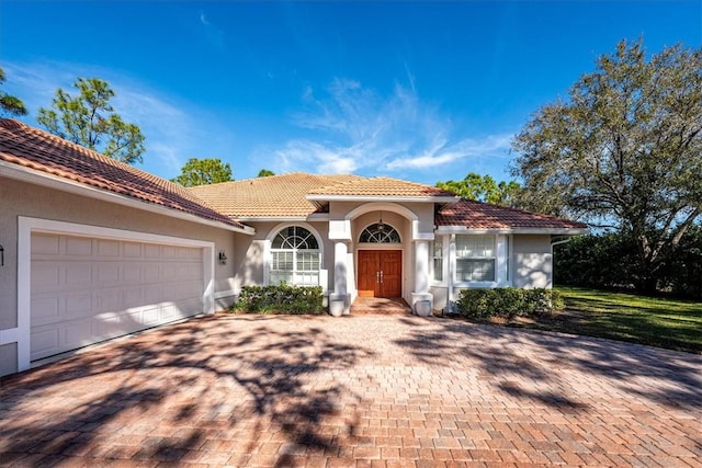 mediterranean / spanish-style house with a garage