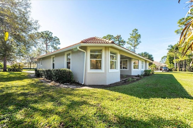 view of side of home with a yard