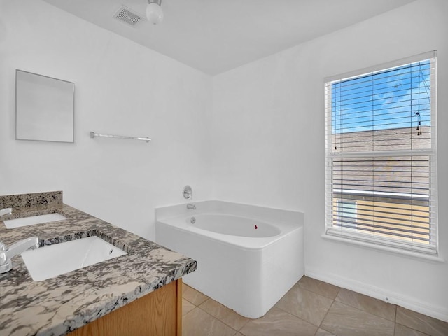 5985 Ridge Lake Cir, Vero Beach, FL 32967 - bathroom with double vanity, a bath, plenty of natural light, and tile patterned flooring