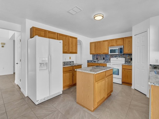 5985 Ridge Lake Cir, Vero Beach, FL 32967 - kitchen featuring white appliances, backsplash, a center island, and light tile patterned flooring