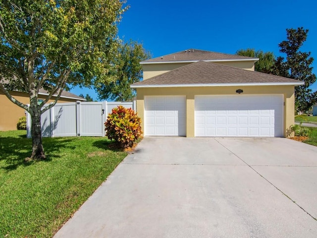 5985 Ridge Lake Cir, Vero Beach, FL 32967 - view of home's exterior with a garage, stucco siding, roof with shingles, concrete driveway, and a gate