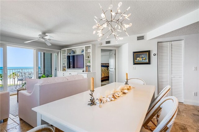 2700 Ocean Dr Unit 405, Vero Beach, FL 32963 - dining area featuring ceiling fan with notable chandelier, a textured ceiling, baseboards, and visible vents